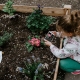 Wir haben 10 Tipps für Dich, wie Du das Klima schützen kannst. Mädchen pflanzt Blumen.