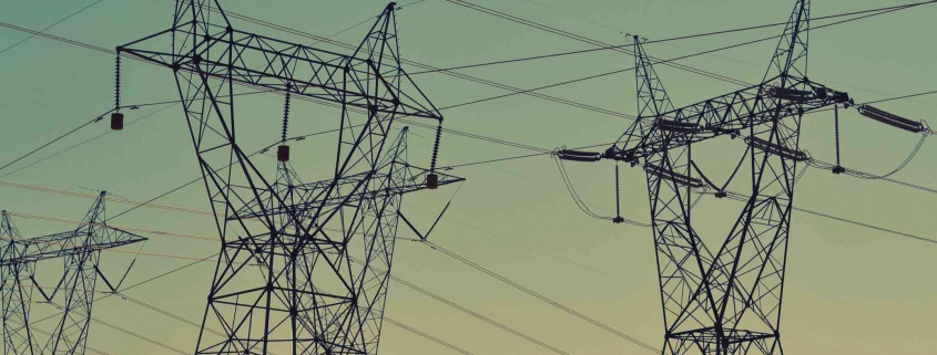 Strom und Erdgas sind so teuer wie nie. Wir erklären Dir, warum das so ist und wie sich der Preis entwickeln könnte. Strommasten vor Sonnenuntergang