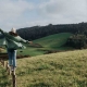 Frau balanciert auf Wiese. Warum leben wir nicht so nachhaltig wie wir wollen?