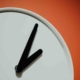 Eine Uhr vor orangem Hintergrund - ab Juni können Stromkunden in Deutschland in 24 Stunden ihren Anbieter wechseln.
